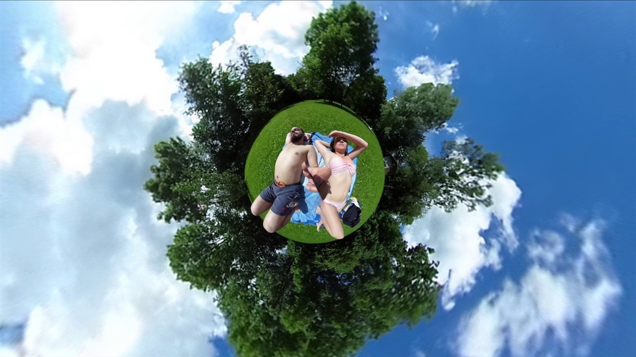 Man and Woman sunbathe, tree, blue skies 