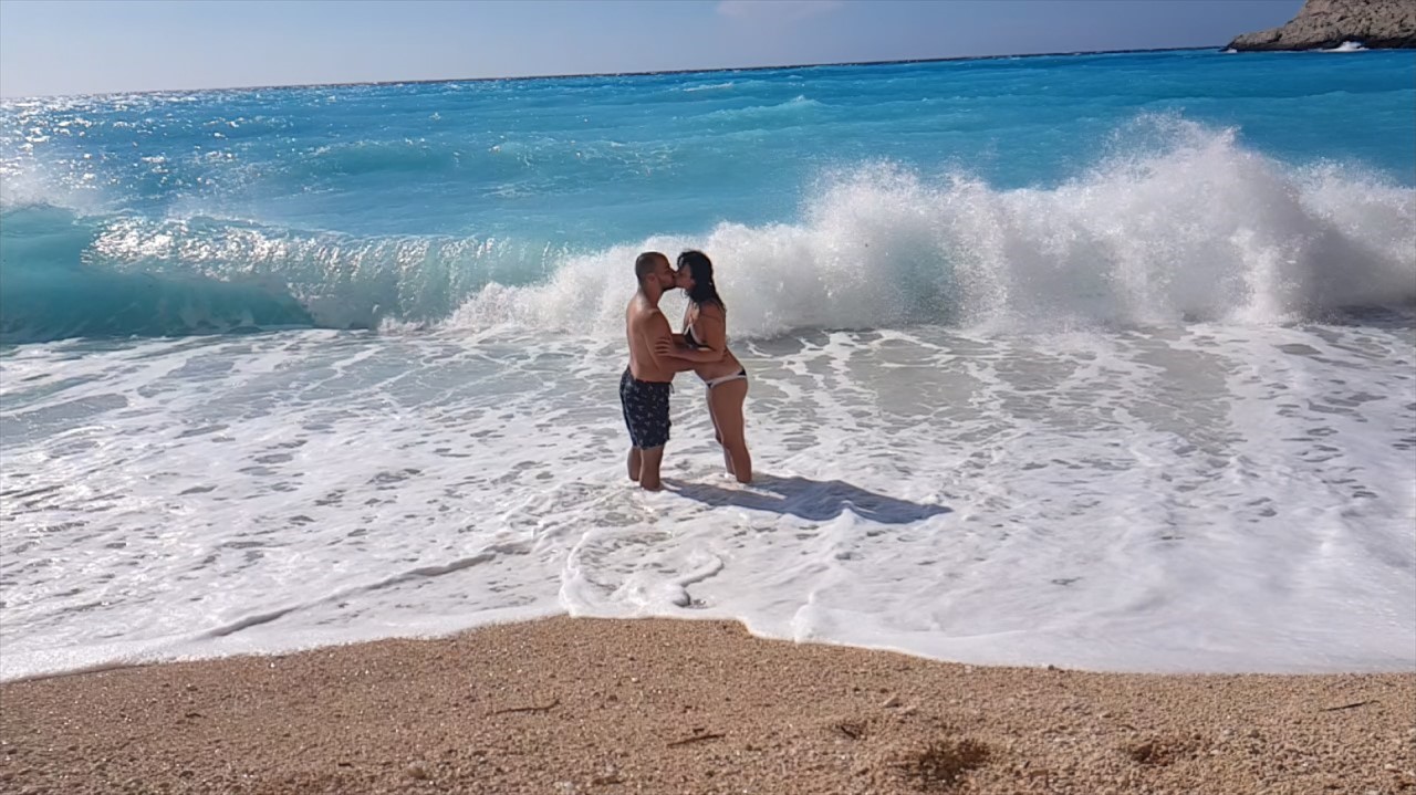 Man and woman kiss in the waves