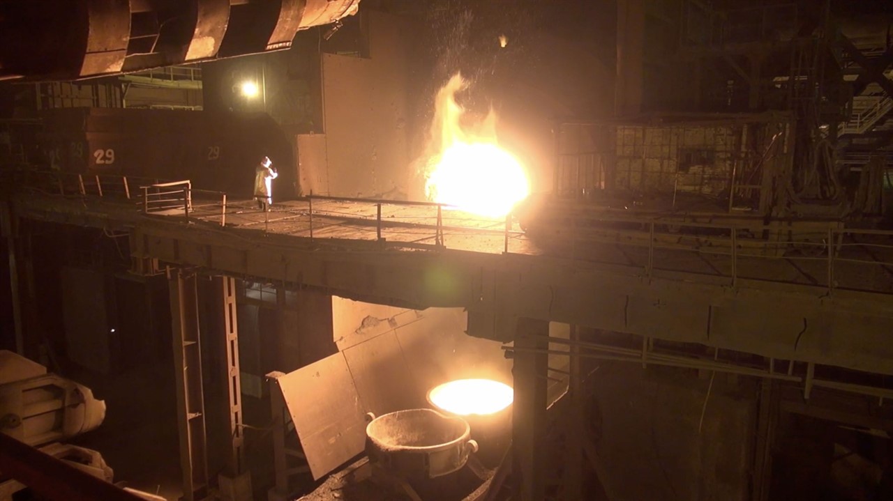 Worker in factory with large ball of fire